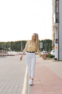 Full length of woman walking on footpath