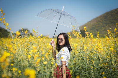 Portrait of smiling young woman standing on field