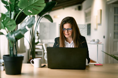 Employee in eyewear working on laptop in office