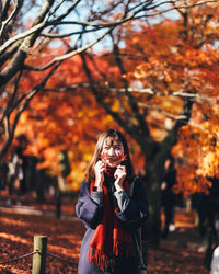 Young woman holding leaves during autumn