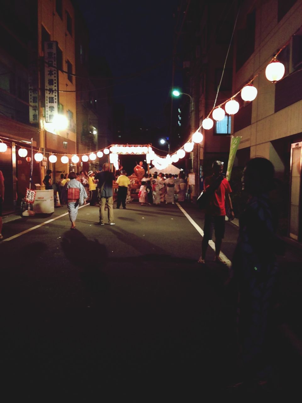 night, illuminated, building exterior, architecture, built structure, street, city, lighting equipment, men, city life, street light, lifestyles, large group of people, walking, person, city street, leisure activity, light - natural phenomenon, road