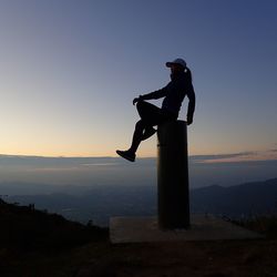 Silhouette man standing on mountain during sunset