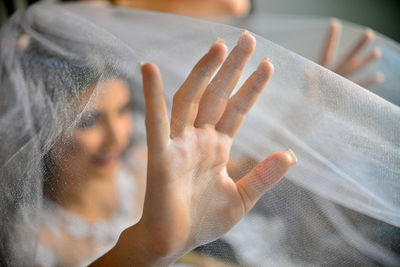 Bride seen through veil while at home