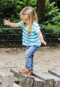 Girl balancing on wooden blocks at park