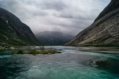 Scenic view of lake by mountains against sky