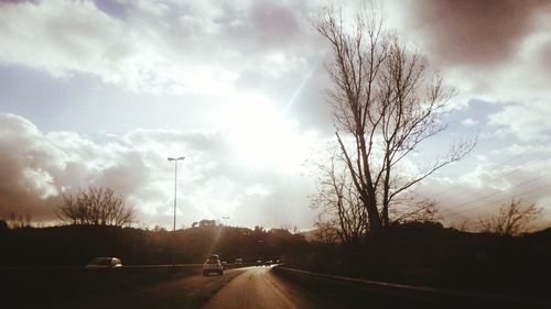 Country road against cloudy sky