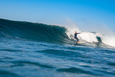 Man surfing in sea against sky