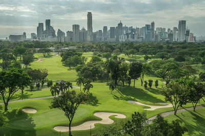 Panoramic view of trees and cityscape against sky