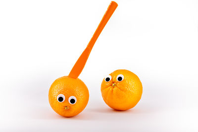 Close-up of orange fruit against white background