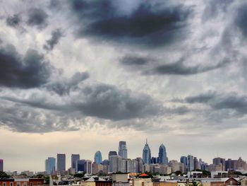 Skyscrapers in city against cloudy sky