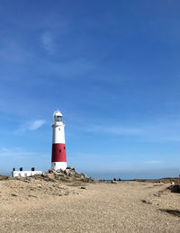 Lighthouse by sea against sky