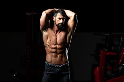 Shirtless man exercising in gym