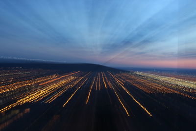 Aerial view of illuminated road against sky at night