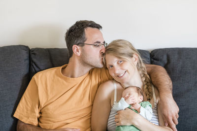 Man kissing woman sitting with baby