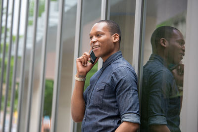 Young man looking through window