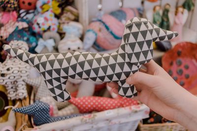 Cropped hand holding patterned toy at market stall