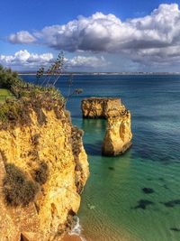 Rock formations by sea against sky