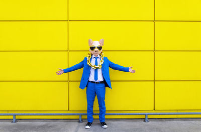 Portrait of boy standing against yellow wall