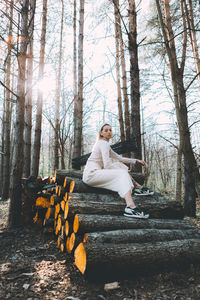 Woman sitting on log in forest