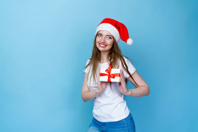 Portrait of a smiling young woman against blue background