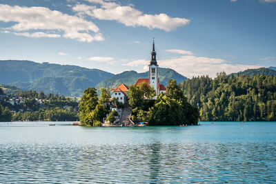 Scenic view of lake by trees and mountains against sky