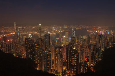 Illuminated cityscape against sky at night