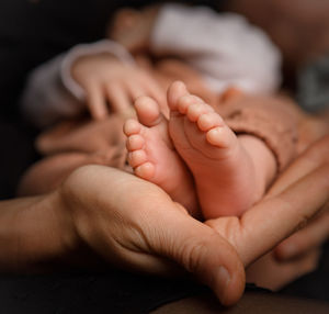 Cropped hands of mother holding baby feet