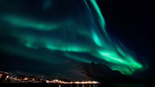 Aerial view of illuminated mountains against sky at night