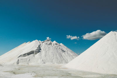 Salt collected on field against blue sky