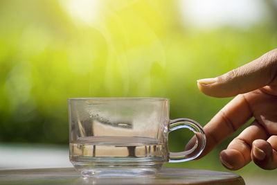 Close-up of hand holding drink against blurred background