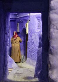 Woman standing against wall in building