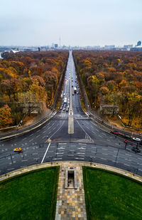 Road leading towards city against sky