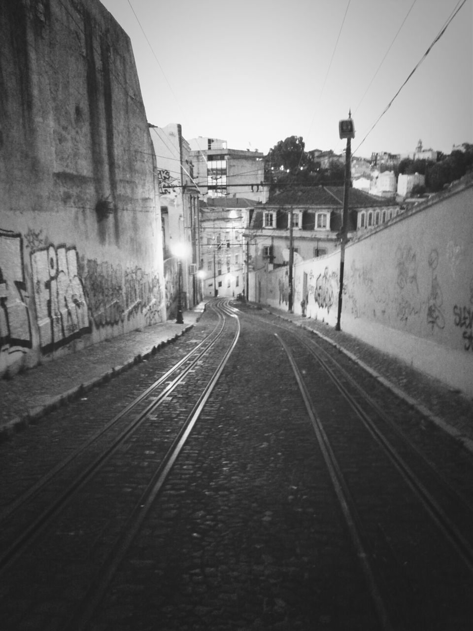 the way forward, transportation, diminishing perspective, architecture, built structure, vanishing point, building exterior, clear sky, road, street, railroad track, empty, sky, long, road marking, day, outdoors, power line, no people, asphalt