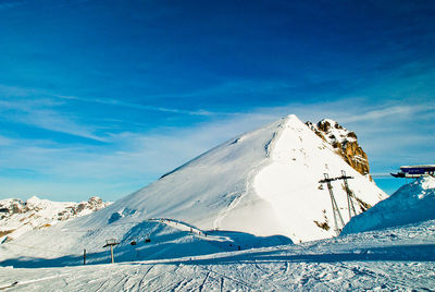 Snow covered mountain against blue sky