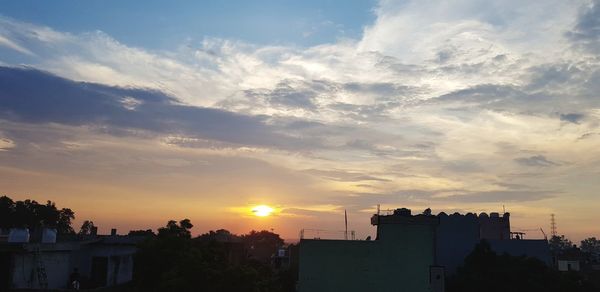 Silhouette buildings against sky during sunset