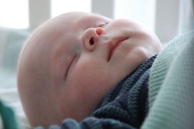 Close-up of baby boy lying on bed