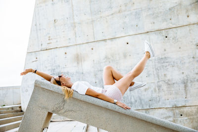 Woman sitting on concrete wall