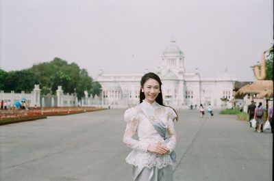 Portrait of smiling woman standing in city