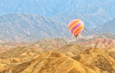 Hot air balloon flying over mountain