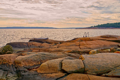 A rocky beach late on a summer day host a diving board and ladder for extra fun 