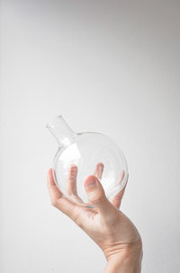 Midsection of person holding glass against white background