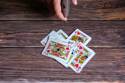 Cropped hand playing poker at table