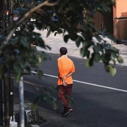 Rear view of man walking on street in city