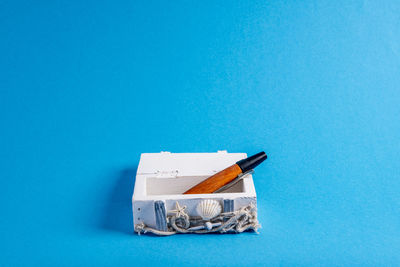 Close-up of pen on table against blue background