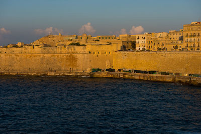 Castle by river against sky