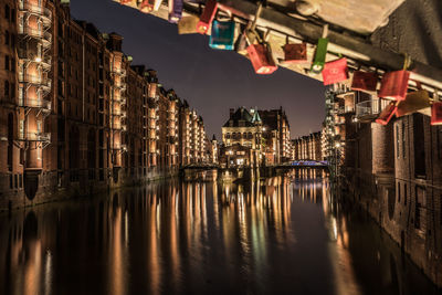 Reflection of buildings in canal at night