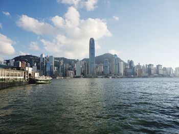 Sea by buildings against sky in city