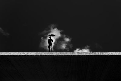 Low angle view of silhouette man standing against sky