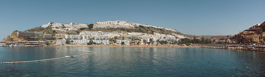 Panoramic view of buildings by sea against sky