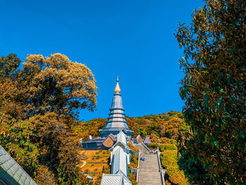 Low angle view of trees and building against sky